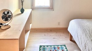 A room with a window, a fan, a picture frame, and a bed. - Moritz - Modern Cabin - Stunning Hunter Mountain View (Hunter)