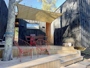 Une terrasse en bois avec des meubles d’extérieur, une table et des chaises.