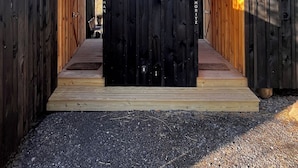 A wooden structure with two open doors leading to interior spaces, a gravel ground, and a clear blue sky. - Moritz - Modern Cabin - Stunning Hunter Mountain View (Hunter)
