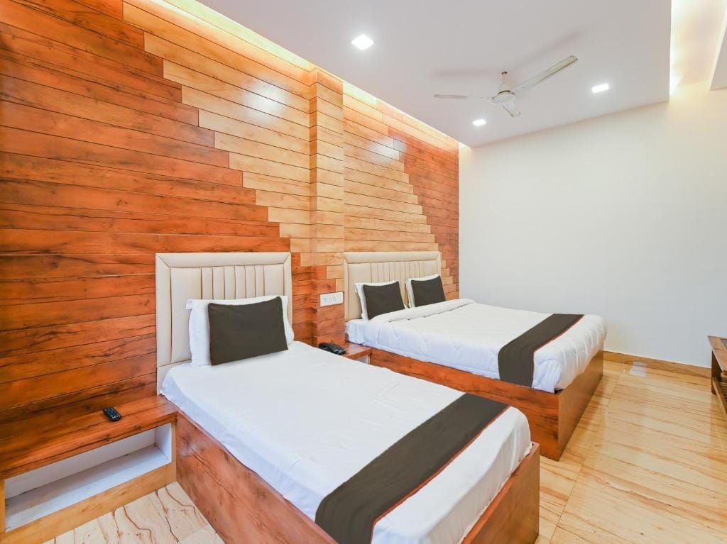 Une chambre d’hôtel avec deux lits, des têtes de lit en bois et un design moderne.
