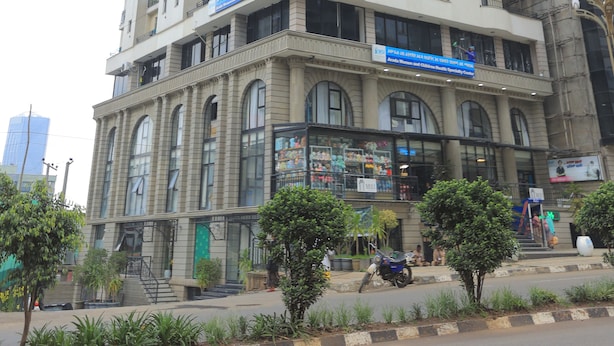 Un edificio de varios pisos con una entrada central, ventanas amplias y techo plano.