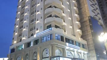 Un hotel a più piani con balconi, un ingresso a livello strada e un cartello che indica che si tratta di un hotel.