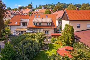 A residential area with houses featuring red-tiled roofs and a church in the background. - Jana's Garden House With Hot Tub (Kamnik)