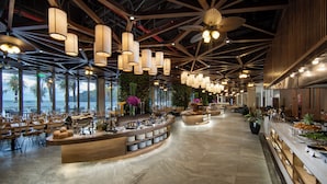 A spacious hotel lobby with a central buffet area, large windows offering views, and a modern ceiling design. - Cat Ba Sea & Sand Resort (Cat Hai)