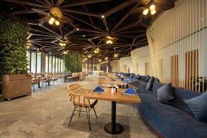 A spacious indoor area with high ceilings, multiple seating arrangements, and a variety of lighting fixtures.