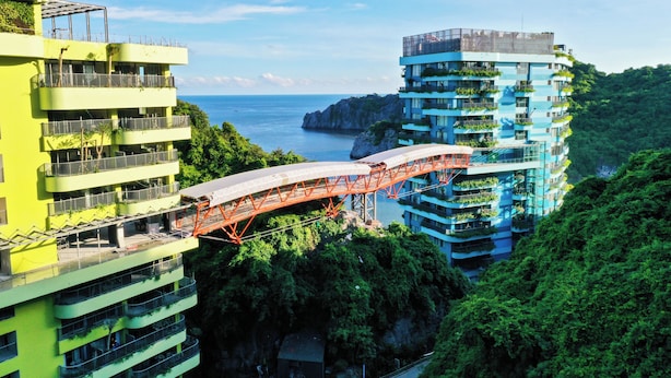 A multi-story hotel with balconies, a bridge, and a view of the sea. - Cat Ba Sea & Sand Resort (Cat Hai)