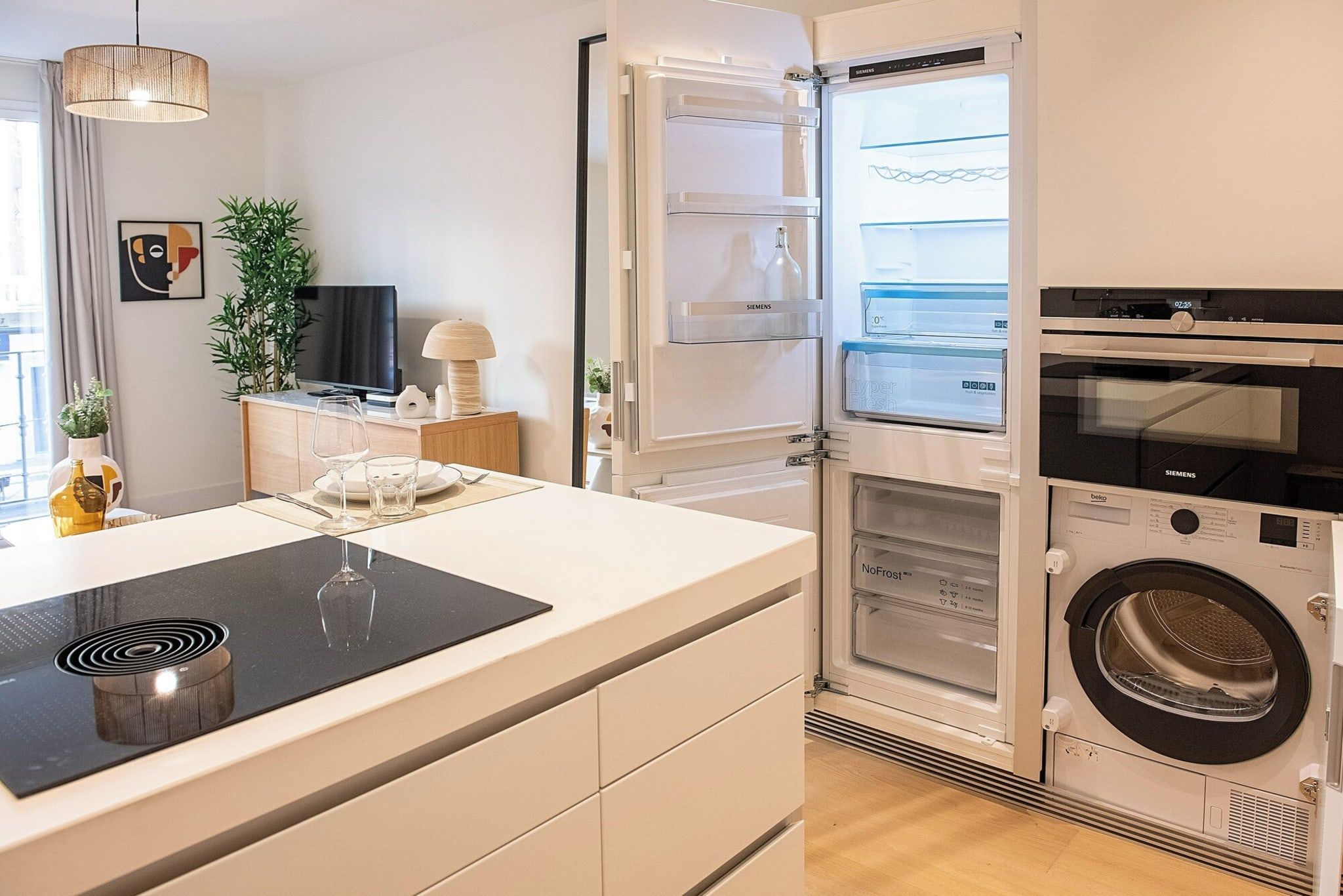 Eine moderne Küche mit integriertem Kühlschrank, Mikrowelle und Waschmaschine.