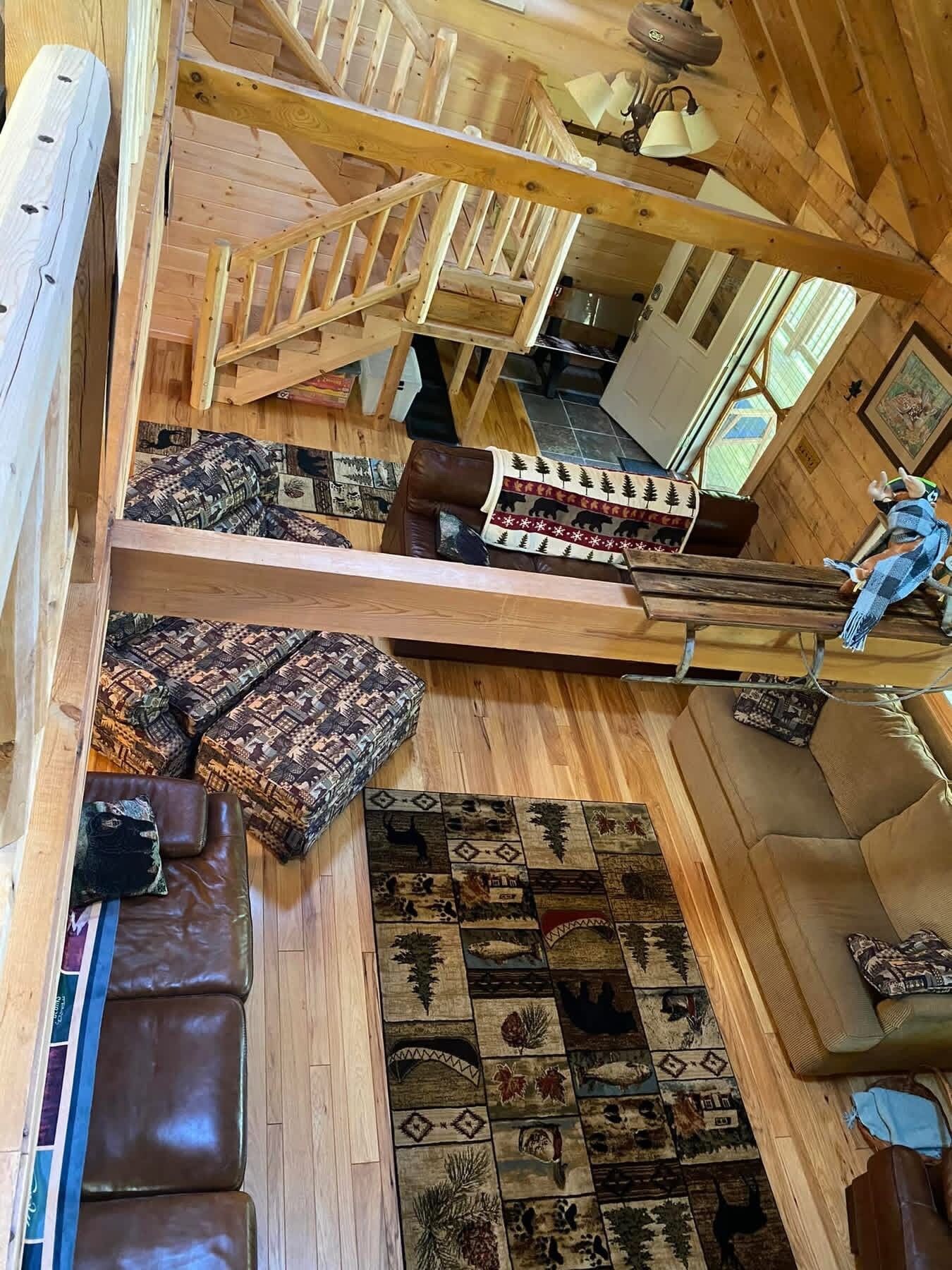 Un intérieur en bois avec un escalier, un tapis à motifs et un banc.