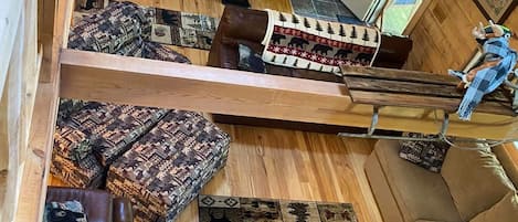 Un intérieur en bois avec un escalier, un tapis à motifs et un banc.