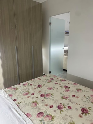 A bedroom with a bed, a wardrobe, and a bathroom visible through a glass door. - Michelina Vacation Home: An apartment of about 45 m² equipped with everything you need (Monte di Procida)