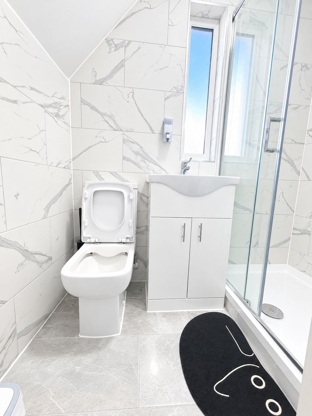A bathroom with a toilet, a sink, and a shower.
