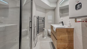 A modern bathroom with a glass shower enclosure, a wooden vanity, and a towel rack. - #IO | Le Victoria 12 💟 (Grenoble)
