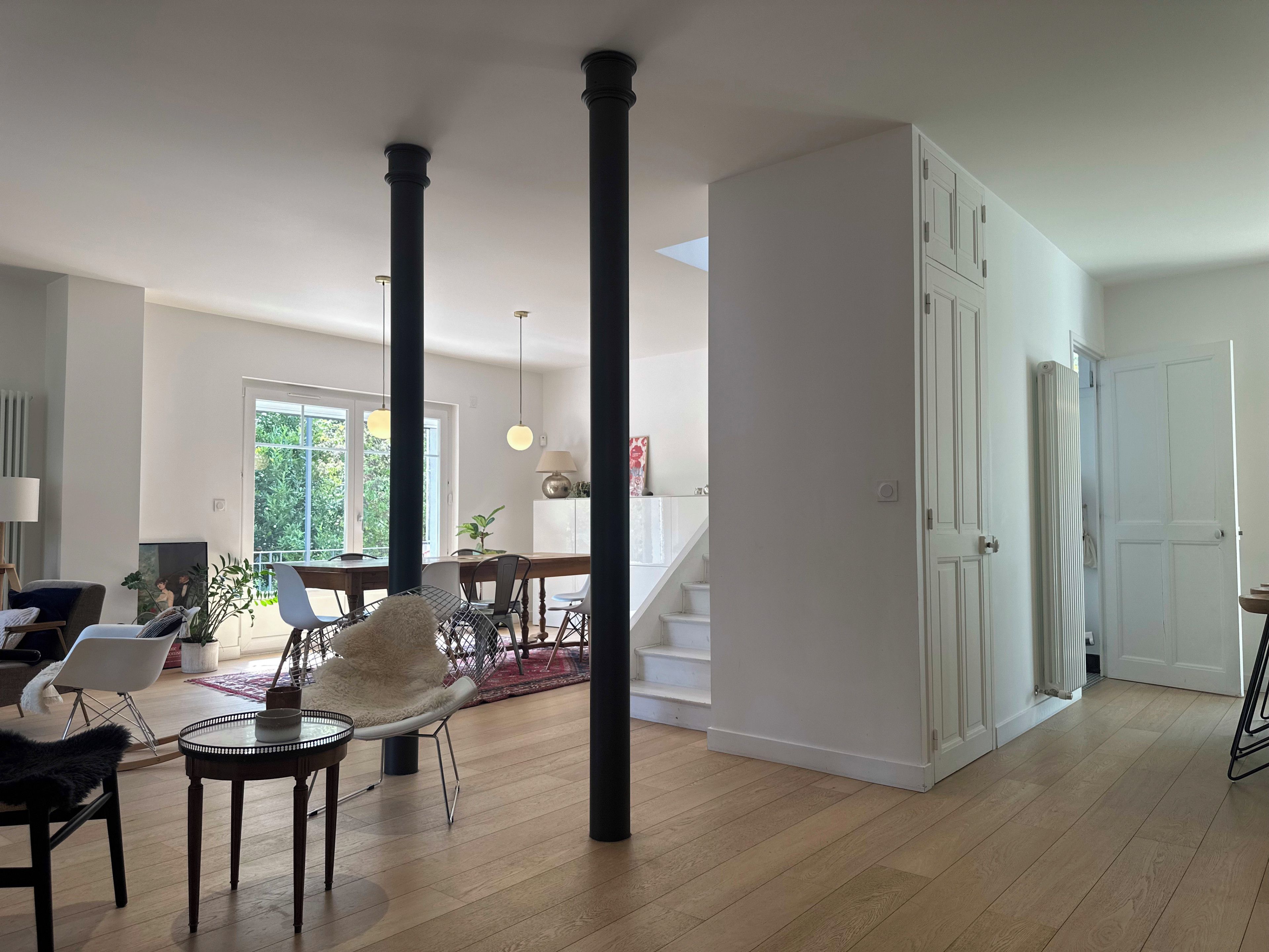 Un vaste espace de vie comprenant une table à manger, des chaises et un escalier menant à l’étage supérieur.