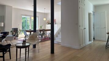 Un vaste espace de vie comprenant une table à manger, des chaises et un escalier menant à l’étage supérieur.