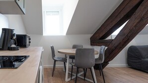 Una cocina moderna con comedor, vigas de madera y vista al cielo.