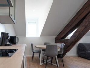 A modern kitchen with a dining area, wooden beams, and a view of the sky. - #IT | L'Amiral 43 💟 - Grenoble (Grenoble)