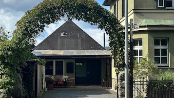 Een gebouw met een overdekte entree, een zichtbare garagepoort en een verharde oprit.