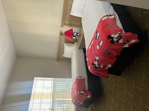 A hotel room with a bed, a nightstand, a lamp, and a window with blinds. - 1403 Spacious 2/2 Resort Condo Near Disney (Orlando)