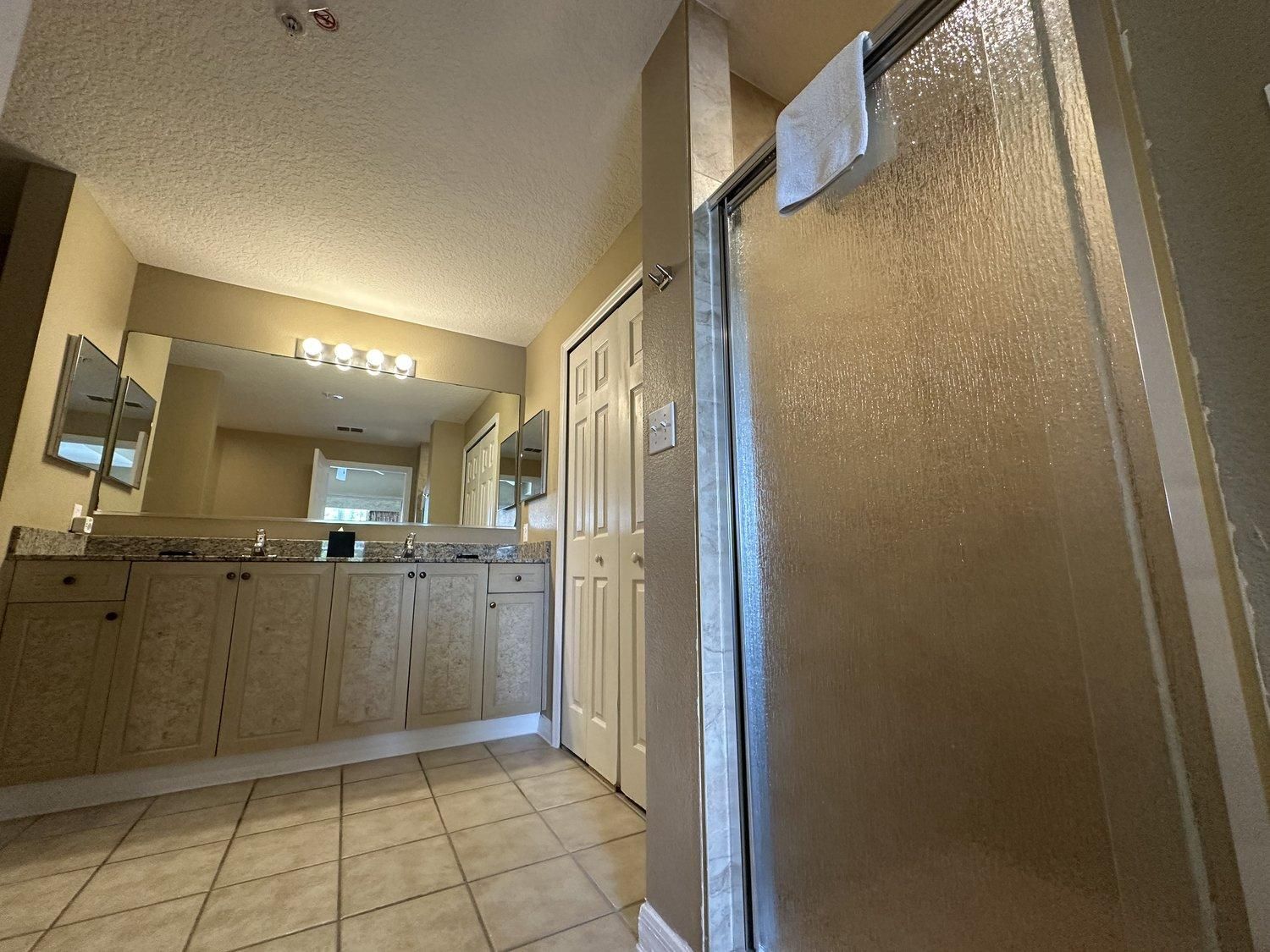 Een badkamer met een wastafel, spiegel en douche.