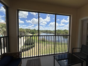 En balkon med udsigt over et søområde og en blå himmel.