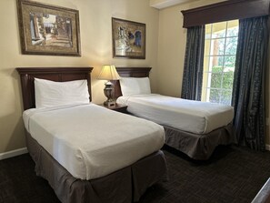 A hotel room with two beds, a nightstand with a lamp, and two framed pictures on the wall. - 4106 Spacious 2/2 Resort Condo Near Disney (Orlando)