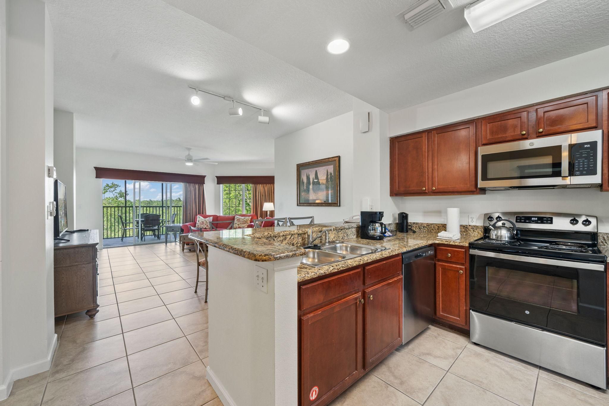 A modern kitchen with granite countertops, stainless steel appliances, and wooden cabinets.