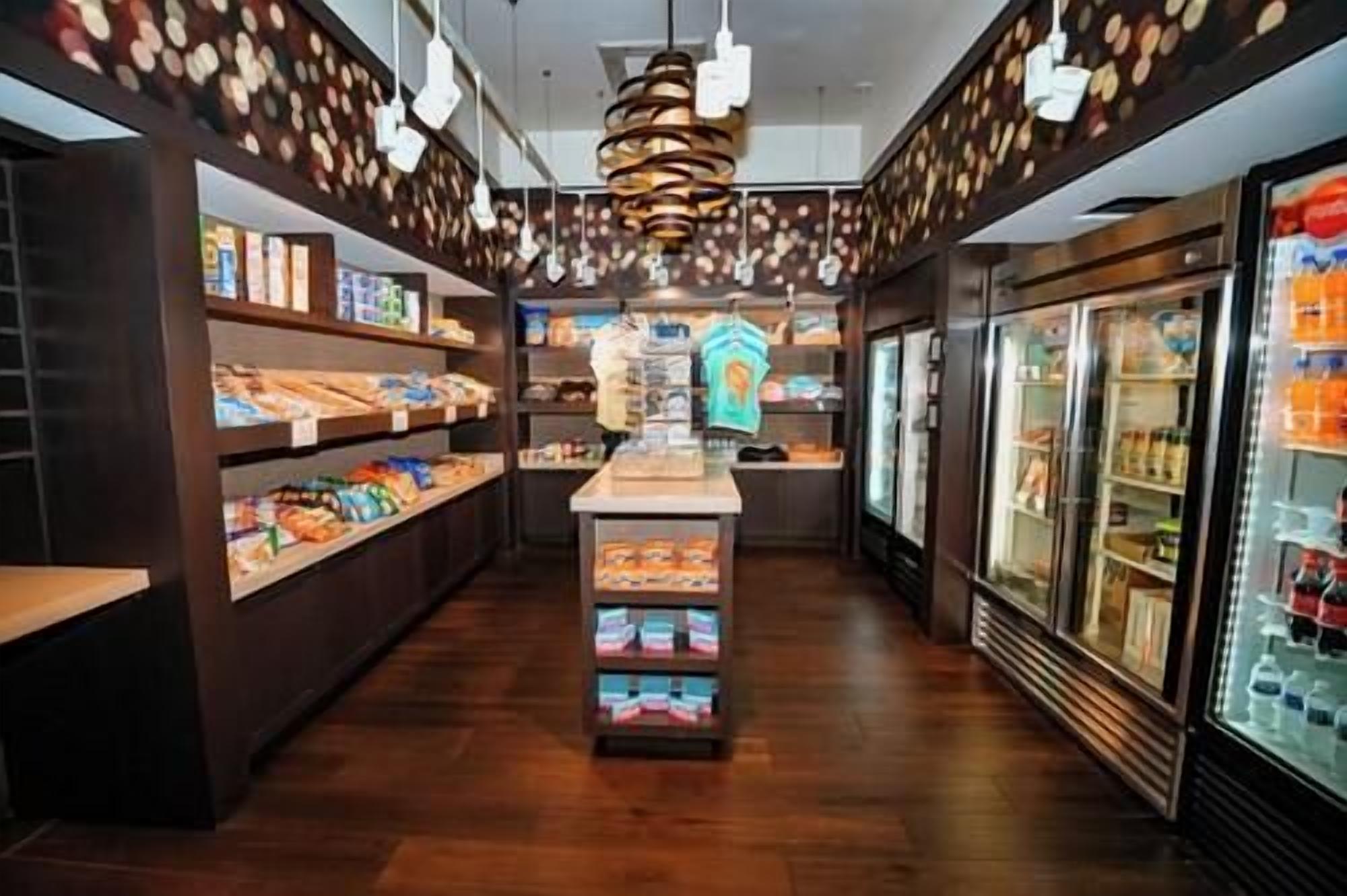 A narrow corridor with shelves stocked with snacks and a central display.