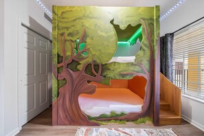 Quarto com cama embutida, janela com persianas e porta.