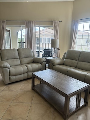 A living room with two sofas, a coffee table, and a lamp. - 6503 Spacious 2/2 Resort Condo Near Disney (Orlando)