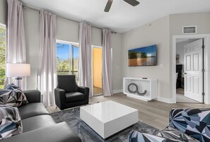 Ein modernes Wohnzimmer mit einer Couch, einem Sessel und einem Couchtisch.