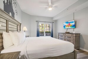 A hotel room with a large bed, a ceiling fan, a TV, and a view of the outdoors. - 1101 Spacious 3/2 Resort Condo Near Disney (Orlando)