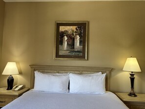 A hotel room with a bed, two bedside lamps, a painting on the wall, and a nightstand with a telephone. - 1207 Spacious 3/2 Resort Condo Near Disney (Orlando)