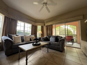 Ein Wohnzimmer mit zwei Sofas, einem Couchtisch und einem Deckenventilator.