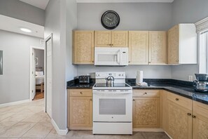 A modern kitchen with a microwave, stove, and toaster. - 2208 Spacious 3/2 Resort Condo Near Disney (Orlando)