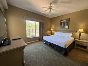 A hotel room with a bed, two bedside lamps, a ceiling fan, a TV, and a window with curtains. - 2307 Spacious 3/2 Resort Condo Near Disney (Orlando)