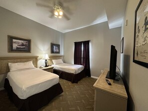 A hotel room with two beds, a ceiling fan, a television, and framed pictures on the walls. - 2507 Spacious 3/2 Resort Condo Near Disney (Orlando)