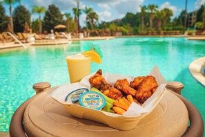 A tray of fried chicken, French fries, and dipping sauces by a poolside. - 3108 Spacious 3/2 Resort Condo Near Disney (Orlando)