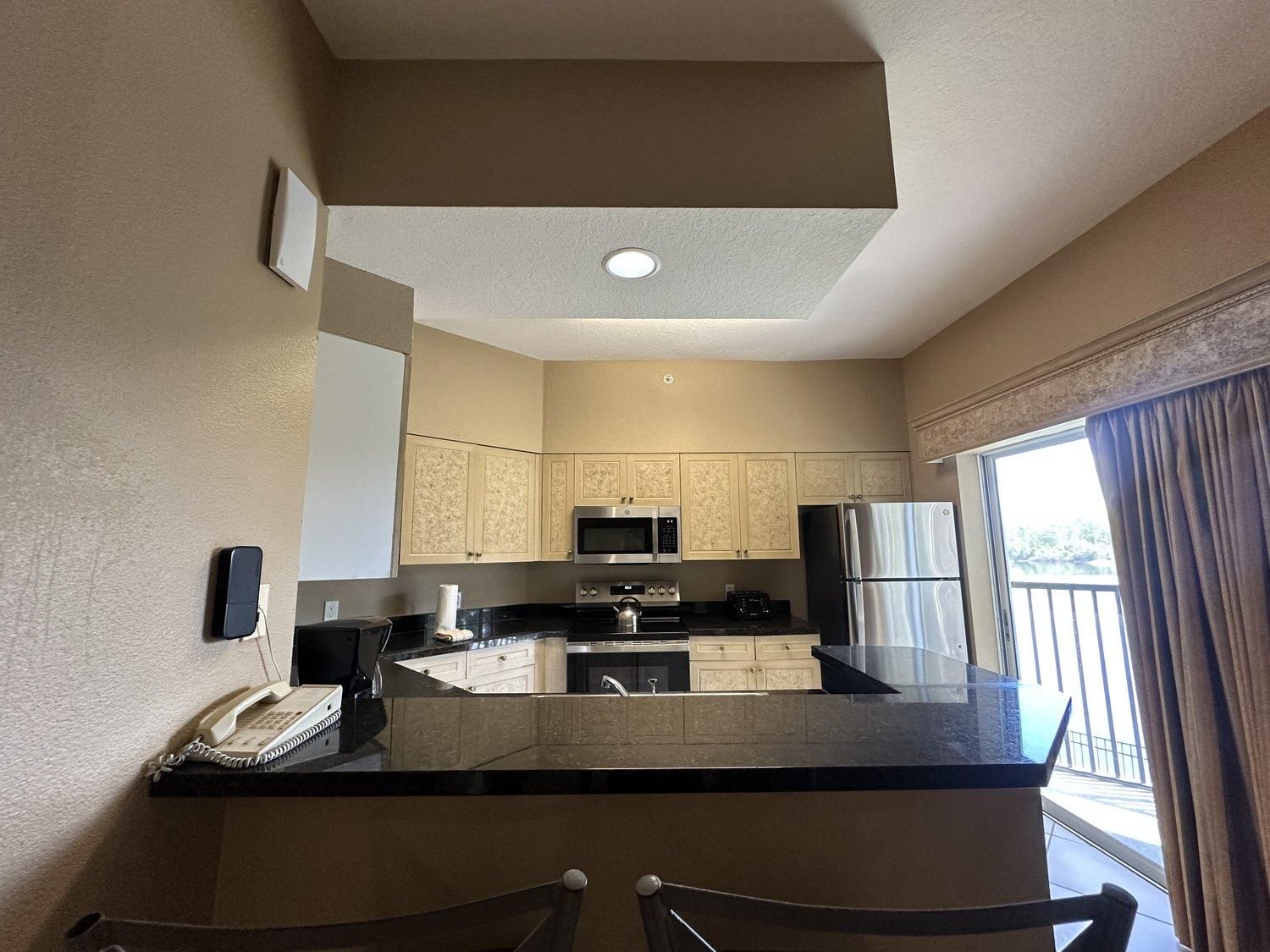 A compact kitchen with a central island, built-in microwave, and stainless steel appliances.