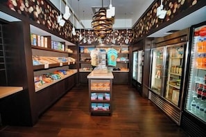 A narrow corridor with shelves stocked with snacks and a central display. - 3307 Spacious 3/2 Resort Condo Near Disney (Orlando)