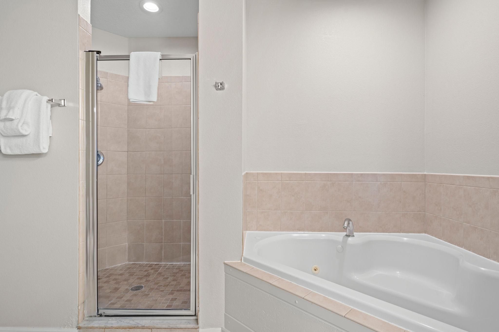 A bathroom with a shower enclosure, a bathtub, and a toilet.