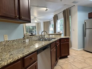 A kitchen with granite countertops, stainless steel appliances, and wooden cabinets.
