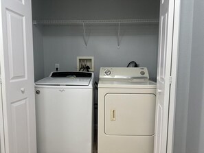 A laundry room with a front-loading washer and a top-loading dryer. - 4201 Spacious 3/2 Resort Condo Near Disney (Orlando)