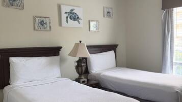 Une chambre d’hôtel avec deux lits, une table de chevet avec une lampe et des œuvres d’art murales.