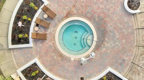 A circular pool with a surrounding tiled walkway, benches, and a small garden area. - 5201 Spacious 3/2 Resort Condo Near Disney (Orlando)