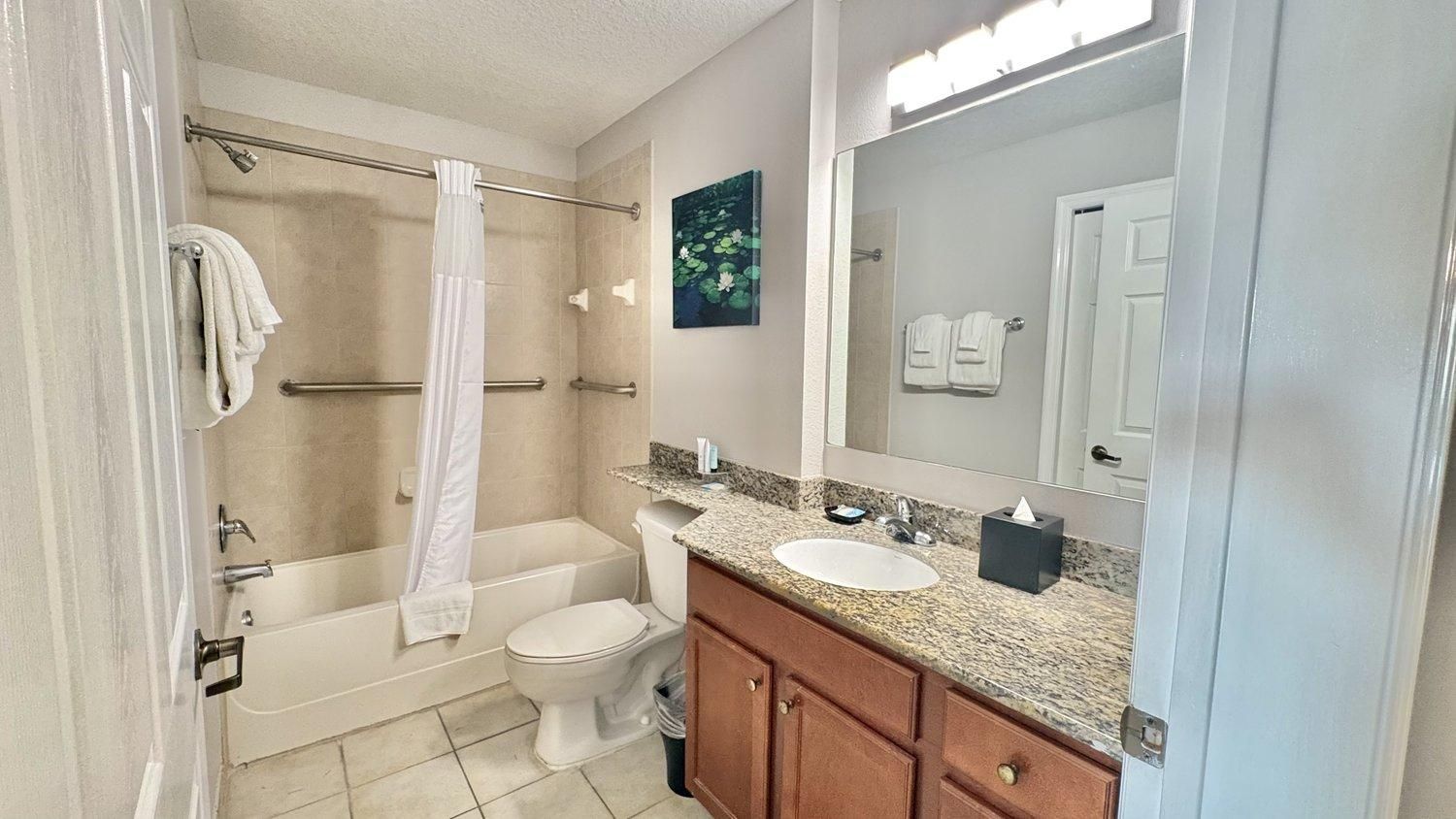 A bathroom with a bathtub, toilet, and sink.