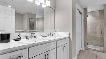 Une salle de bain moderne avec un meuble-lavabo à deux vasques, un grand miroir et une douche à l’italienne.