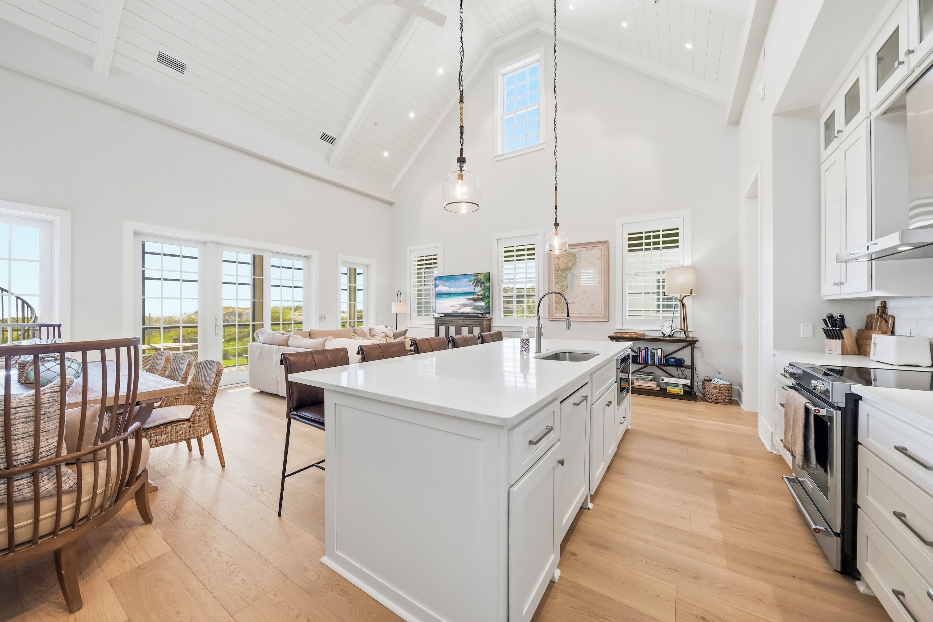 Una cocina amplia con una isla grande, muebles blancos y un diseño moderno.