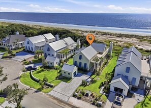 A residential area with multiple houses, a beach, and a clear sky. - Oceanfront Jekyll Island • 3 King Bedrooms • Screened Porch • Walk to Dining (Jekyll Island)
