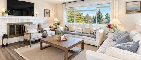 A living room with a fireplace, a sofa set, a coffee table, and a television.