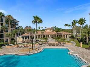 Ein Resort mit Pool, Palmen und einem Gebäude mit mehreren Balkonen.